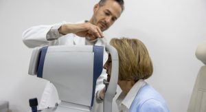 A patient puts her head inside a high street optometry scanner