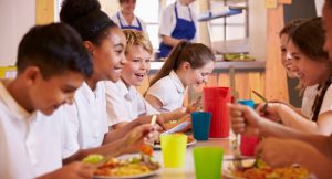 Image shows school children having lunch