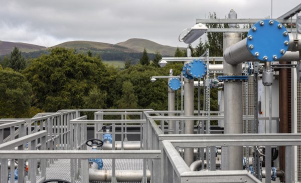 Supercomputing facility chilled water distribution pipework connected to roof mounted cooling towers  with Edinburgh hills in the background