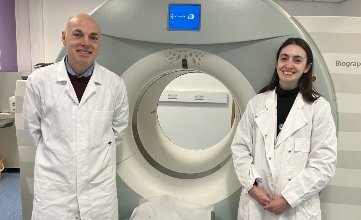 Prof Andy Sutherland and Dr Adriana Tavares in front of a patient scanner at QMRI Edinburgh