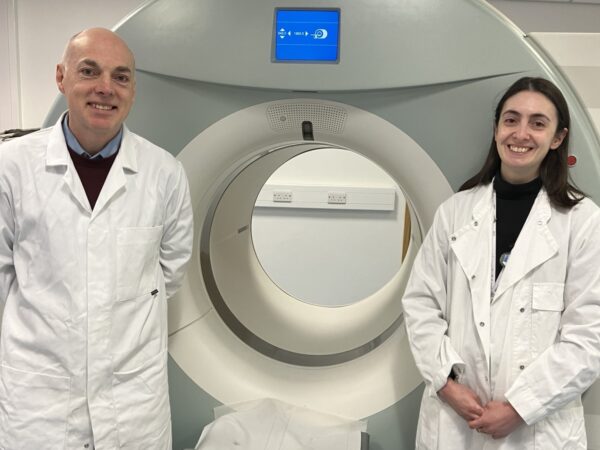 Prof Andy Sutherland and Dr Adriana Tavares in front of a patient scanner at QMRI Edinburgh