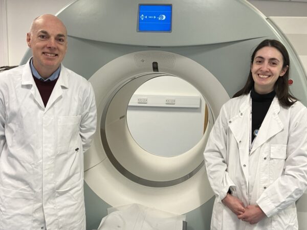 Prof Andy Sutherland and Dr Adriana Tavares in front of a patient scanner at QMRI Edinburgh